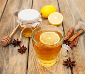 Cup of tea with spaces and honey on a wooden background